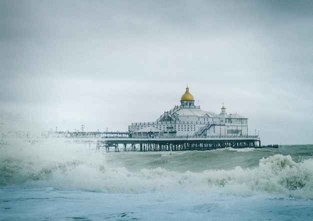 海に強い波があるイギリスのイーストボーンピアの眺め 無料の写真