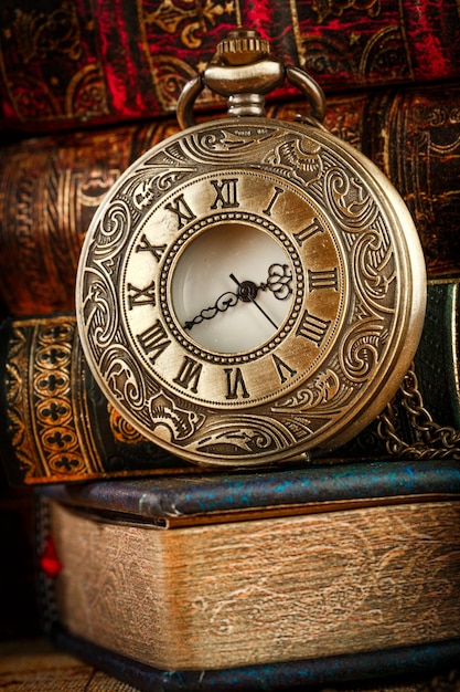 Premium Photo | Vintage antique pocket watch on the background of old books