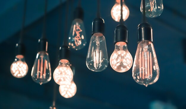 Vintage Glowing Filament Light Bulb Lamps Hanging On The Wall With Retor Blue Color Backgr Premium Photo