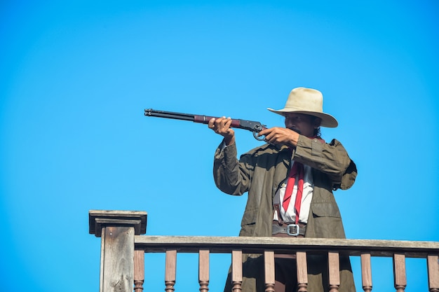 Premium Photo | Vintage image of a cowboy holding a rifle in his hand ...