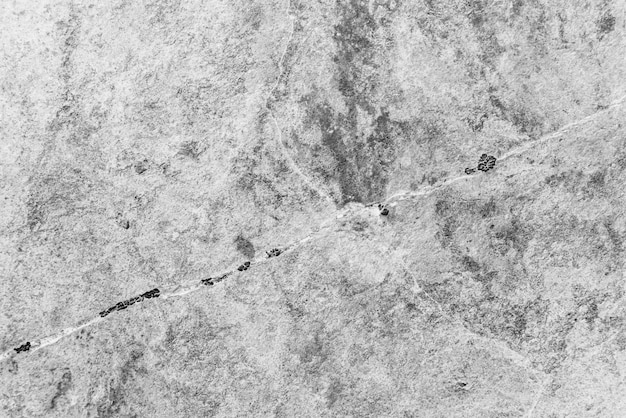 ビンテージのモノクロ背景 黒と白の色の粗く塗られた壁 グレースケールの不完全な平面 不均一な古い装飾的な背景 黒白のテクスチャ 単色の装飾的な石の表面 プレミアム写真