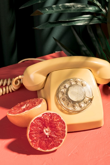 Free Photo | Vintage yellow telephone next to halved grapefruit