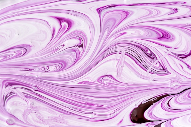 紫と白の絵の具が混ざり合って 美しい抽象的な模様を作り出しています プレミアム写真