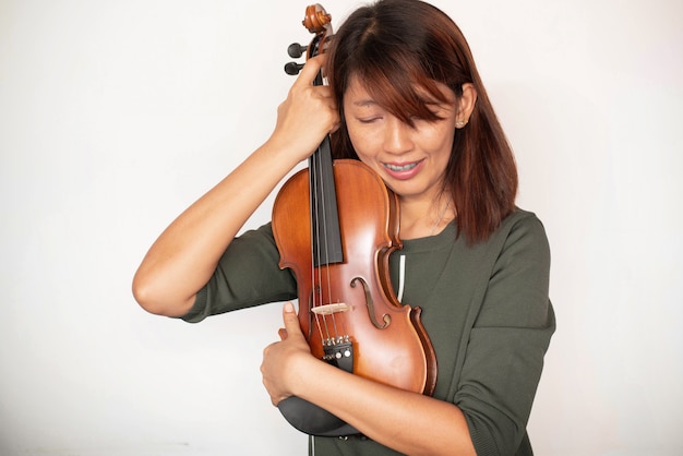 バイオリンはアコースティック楽器でポーズをとる女性 モデルに抱かれていました プレミアム写真