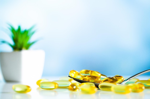  Vitamins supplements, fish oil in yellow capsules omega 3. Premium Photo