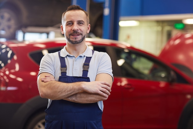 Premium Photo | Waist up portrait of muscular car mechanic standing ...