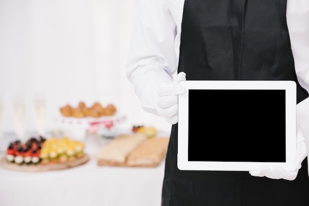 Download Premium Photo Waiter In Uniform Holding A Tablet With Mock Up