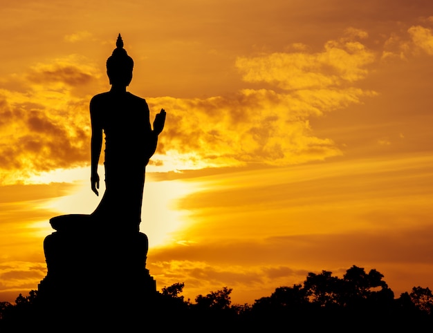 Premium Photo | Walking buddha statue silhouette at sunset