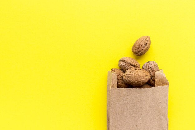 Download Premium Photo Walnuts In Craft Paper Bag On Yellow Background Delicious Nuts Healthy Nutrition Super Food Flat Lay Top View With Copy Space PSD Mockup Templates