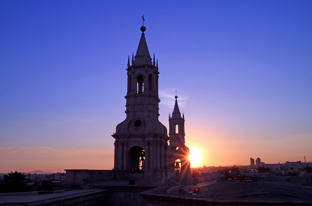 The warm light of setting sun shining through the bell tower of basilica cathedral of arequipa, peru Premium Photo