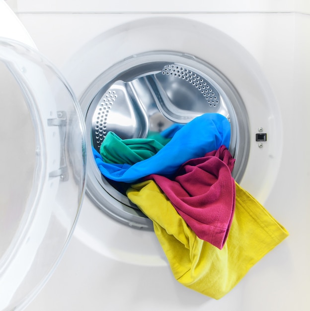 Premium Photo | Washing machine loaded with colorful clothes close-up.