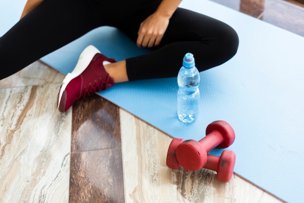 Free Photo | Water bottle and weights on yoga mat