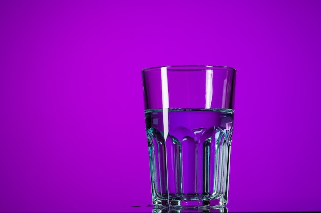 Premium Photo | The water in glass on lilac background