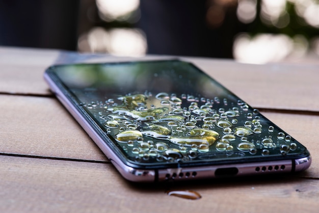 Premium Photo | Water spilled onto the smartphone drops of water on ...