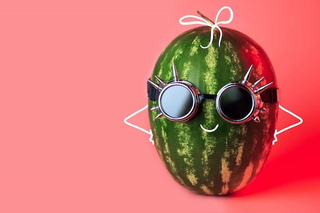 A watermelon punk in rocker glasses on pink background Premium Photo