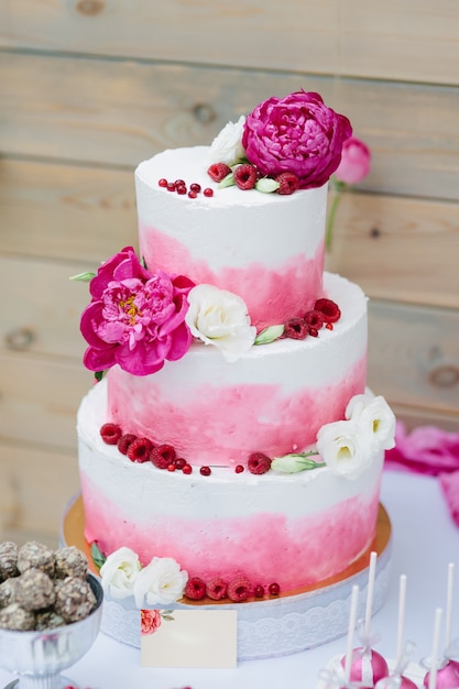 花飾りとピンククリームのウェディングケーキ プレミアム写真