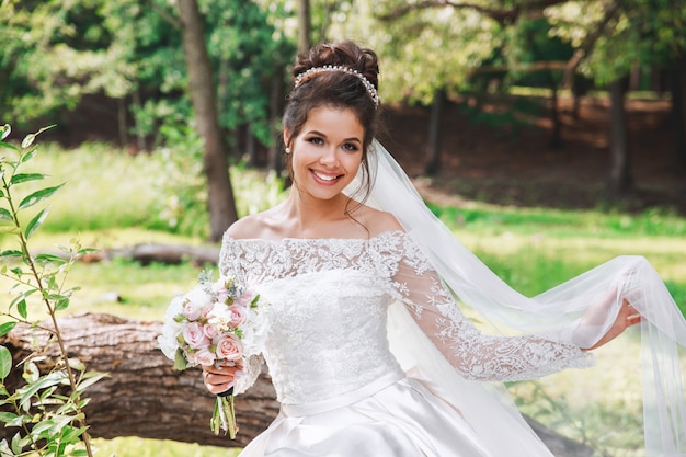 結婚式の日 髪型と化粧白いドレスとベールでポーズをとって若い美しい花嫁 プレミアム写真