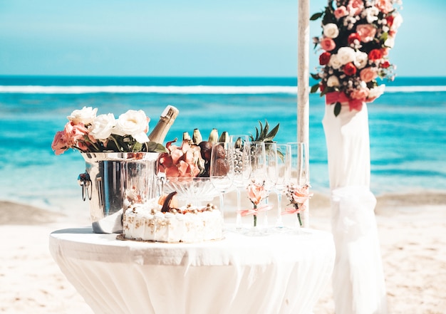 Wedding elegant table with tropical fruits and cake on the beach Free Photo