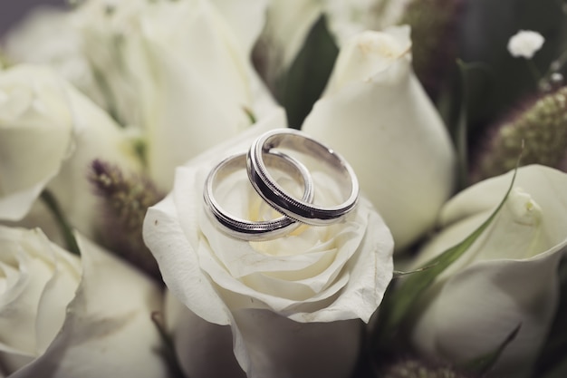 Premium Photo | Wedding rings on white rose bouquet