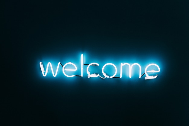 Premium Photo | Welcome neon sign on brick wall background