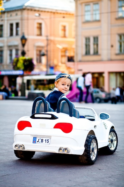 どうしたの 魅力的な少年が小さな白いbmwのカリオをドライブ 無料の写真