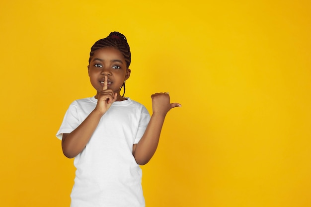 Premium Photo | Whispering a secret, pointing. little african-american ...