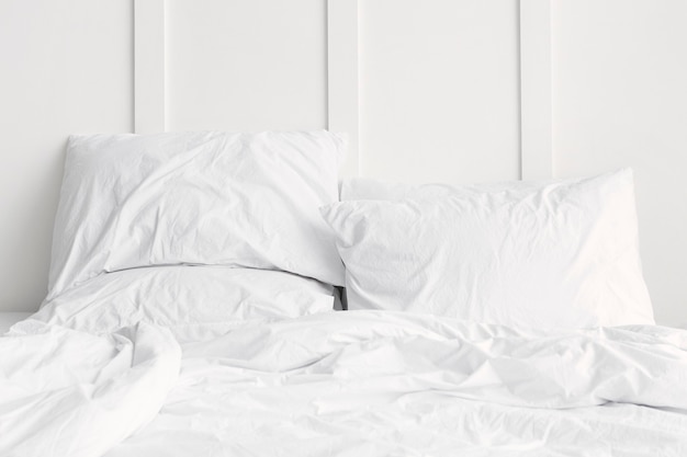 White bed linen on a bed in a white bedroom Free Photo