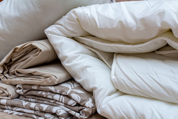 White and beige packed pile of the linen bedclothes blanket with pillow ...