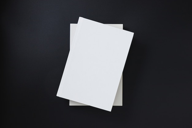 Premium Photo | White book covers stacked on a black background