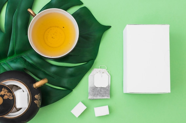 Download Premium Photo Two Tea Bags On The Side Of White Box Over The Green Background PSD Mockup Templates