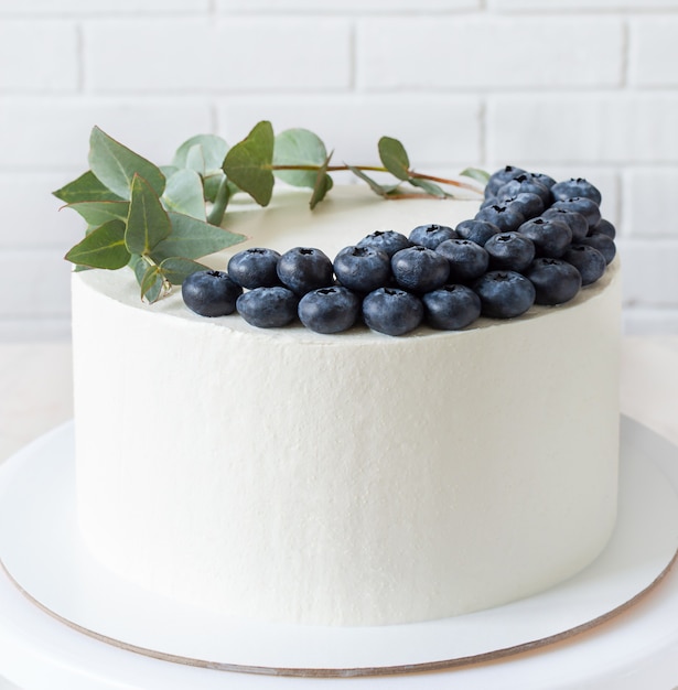 Premium Photo | White cake with blueberries and a sprig of eucalyptus ...