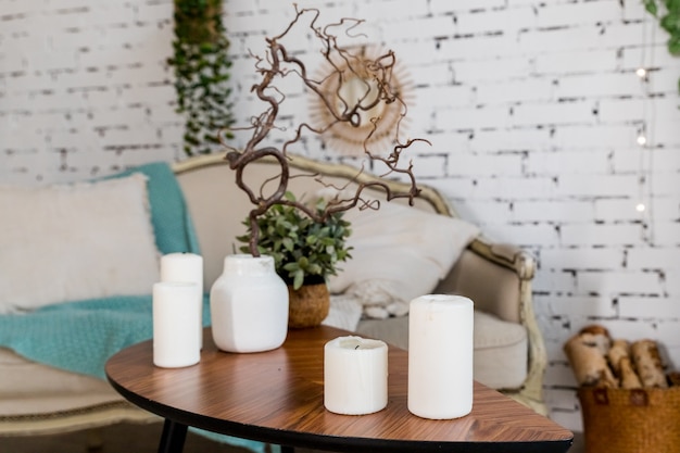 Premium Photo White Candles On Wooden Coffee Table In Cozy Living Room Interior Stylish Scandinavian Living Room Candle And Plant In Vase On Small Wooden Table In Front Of Scandinavian Designed Sofa Boho