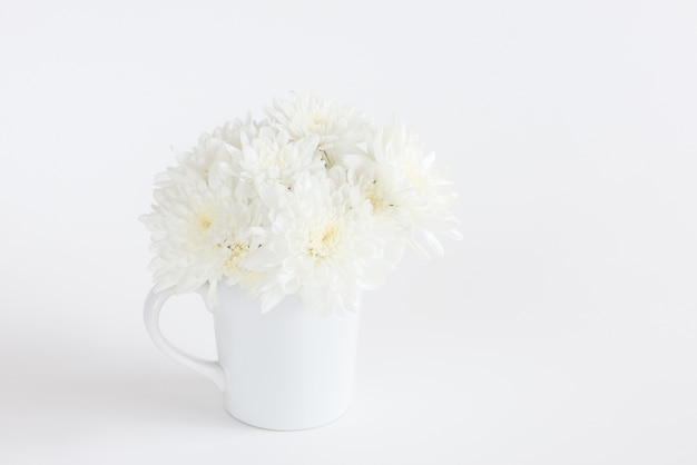 白い菊の花は 白い背景にセラミックカップ プレミアム写真