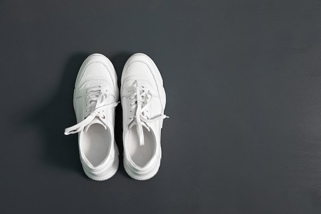 Premium Photo | White fashionable sneakers for women on grey surface