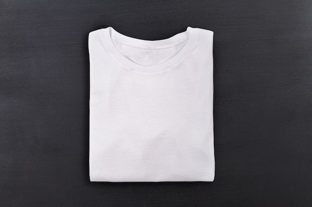 Premium Photo | White folded t-shirt on black chalkboard background