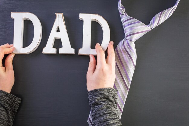 Premium Photo | White letters dad on a painted wood background.