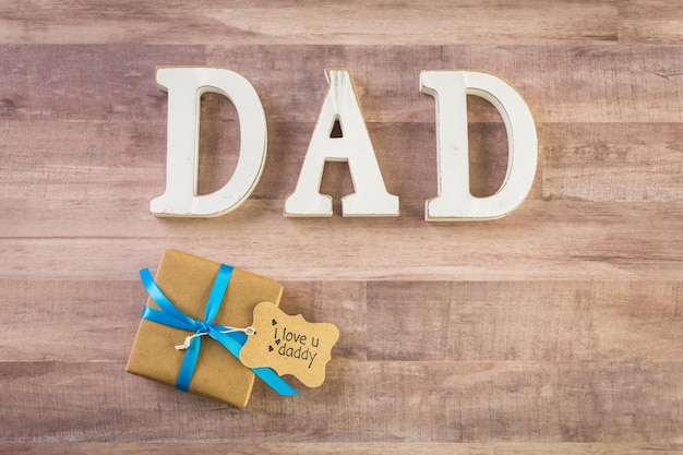 Premium Photo | White letters dad on a wood background.