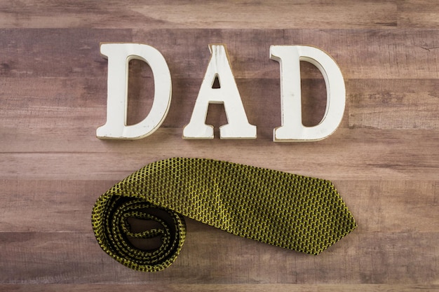 Premium Photo | White letters dad on a wood background.