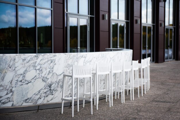 Premium Photo | White marble bar counter with high chairs on the background