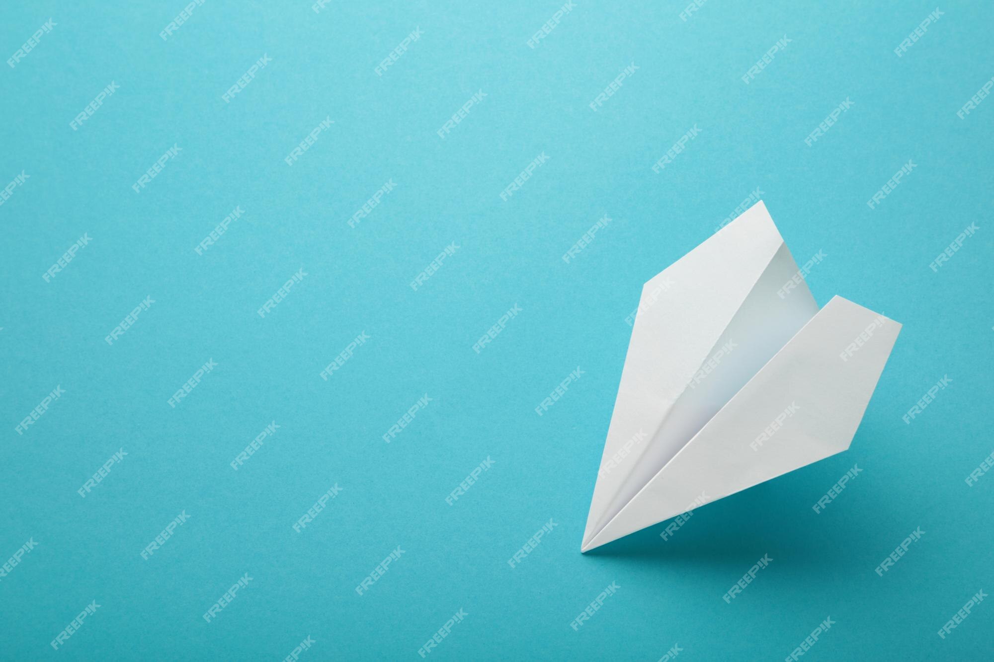 Premium Photo | White paper airplane on a blue background