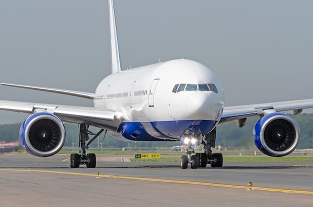 Premium Photo | White passenger airplane rides the track taxiway at the ...