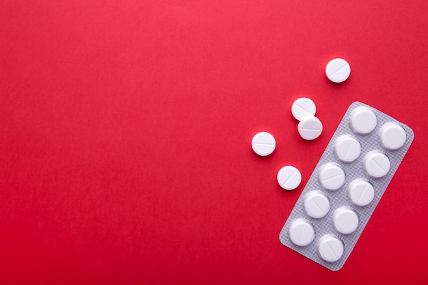 White pills on red with copy space Premium Photo