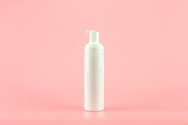 White plastic cosmetic lotion bottle on pink background. Premium Photo