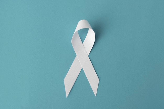 Premium Photo | White ribbon on blue background, cancer awareness concept