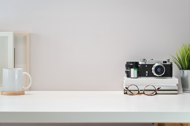 White Scandinavian Workspace Desk With Vintage Camera Films