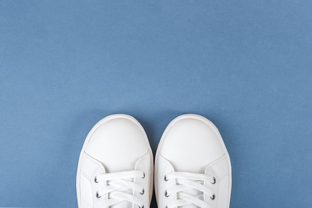White sports shoes, sneakers with shoelaces on blue | Premium Photo