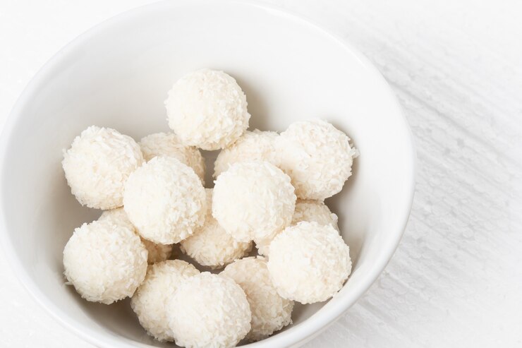 Premium Photo | White sweets with coconut, nuts and cream in a plate on ...