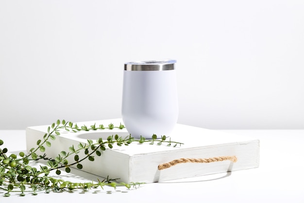 Premium Photo | White thermo cup mock up with green plant on wooden