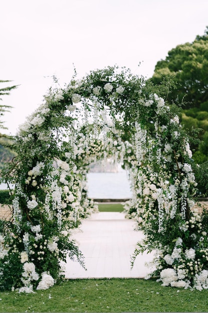 Premium Photo | White walkway through a row of wedding arches on a ...