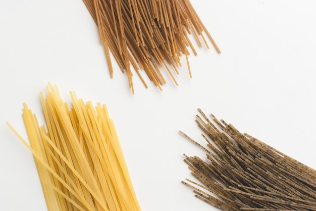 Whole-grain pasta spaghetti tricolora on a white background Free Photo